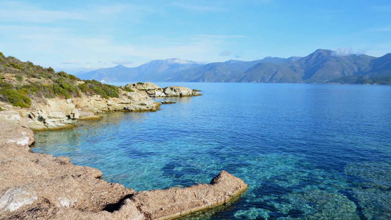 Scenic view of the rugged coastline and clear blue sea in Patrimonio, Corsica, France.